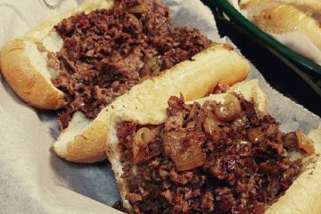 Two chopped steak sandwiches with grilled onions