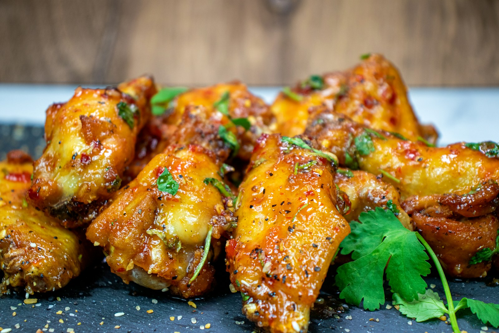 Glazed chicken wings with drumettes and flats on a dark board
