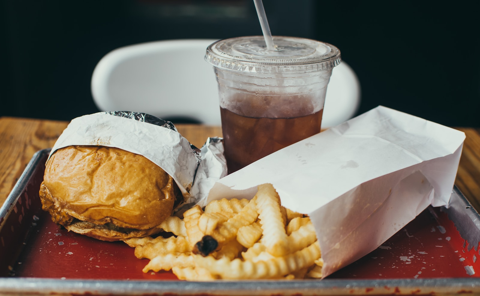 A burger, fries and a drink served together on a tray