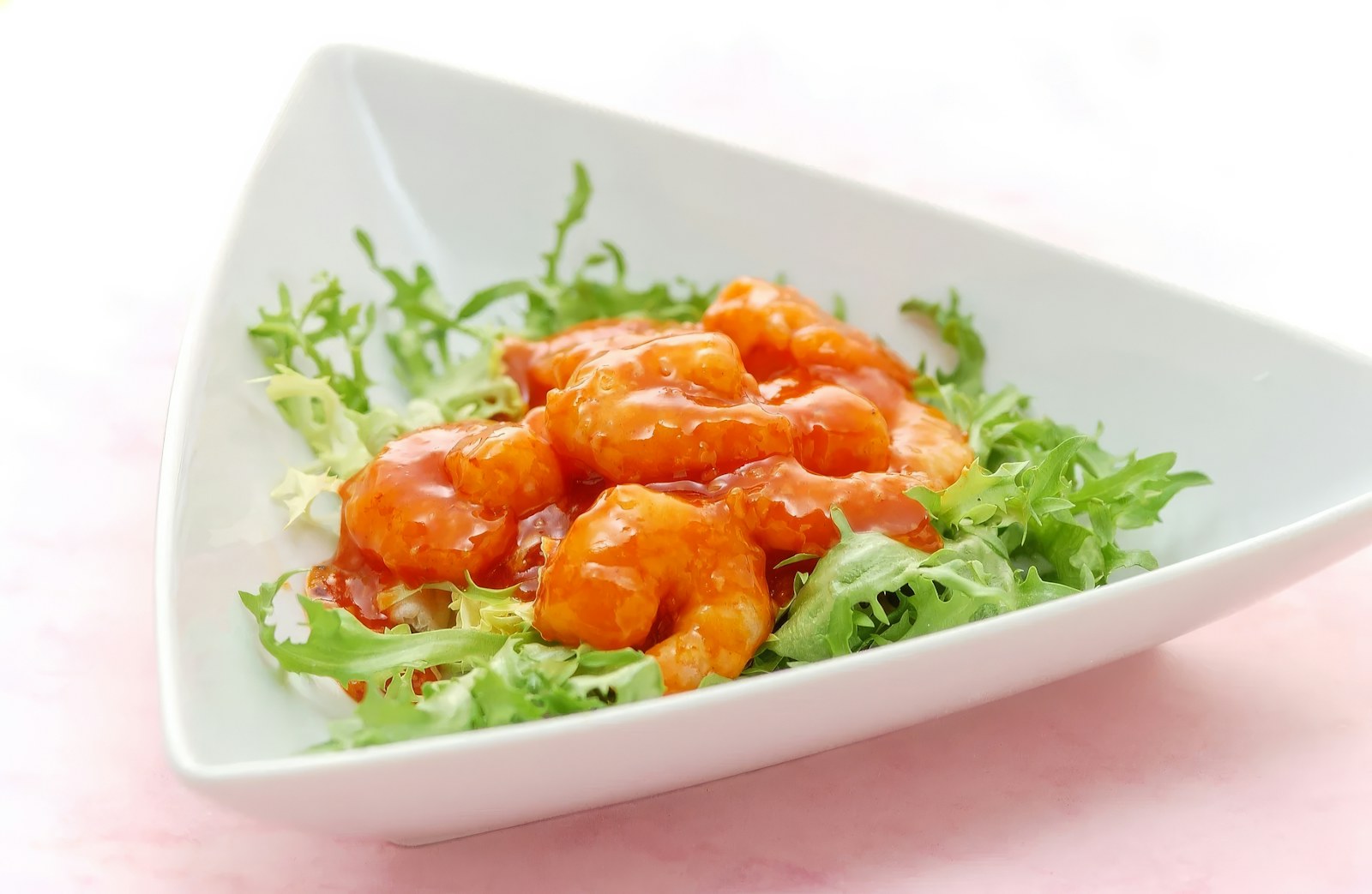 Shrimp coated in buffalo sauce served on lettuce