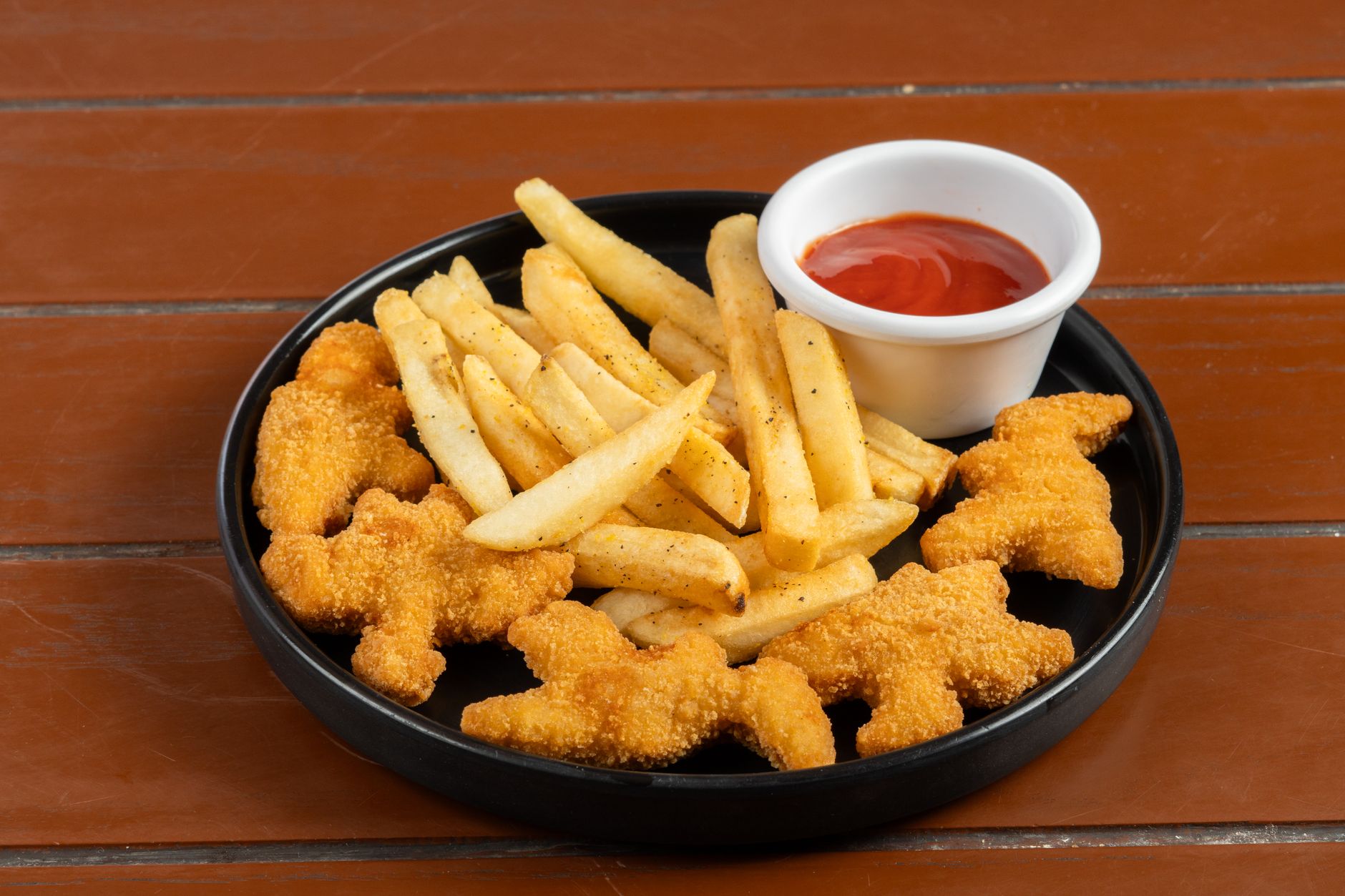 Breaded chicken nuggets with fries and a cup of ketchup