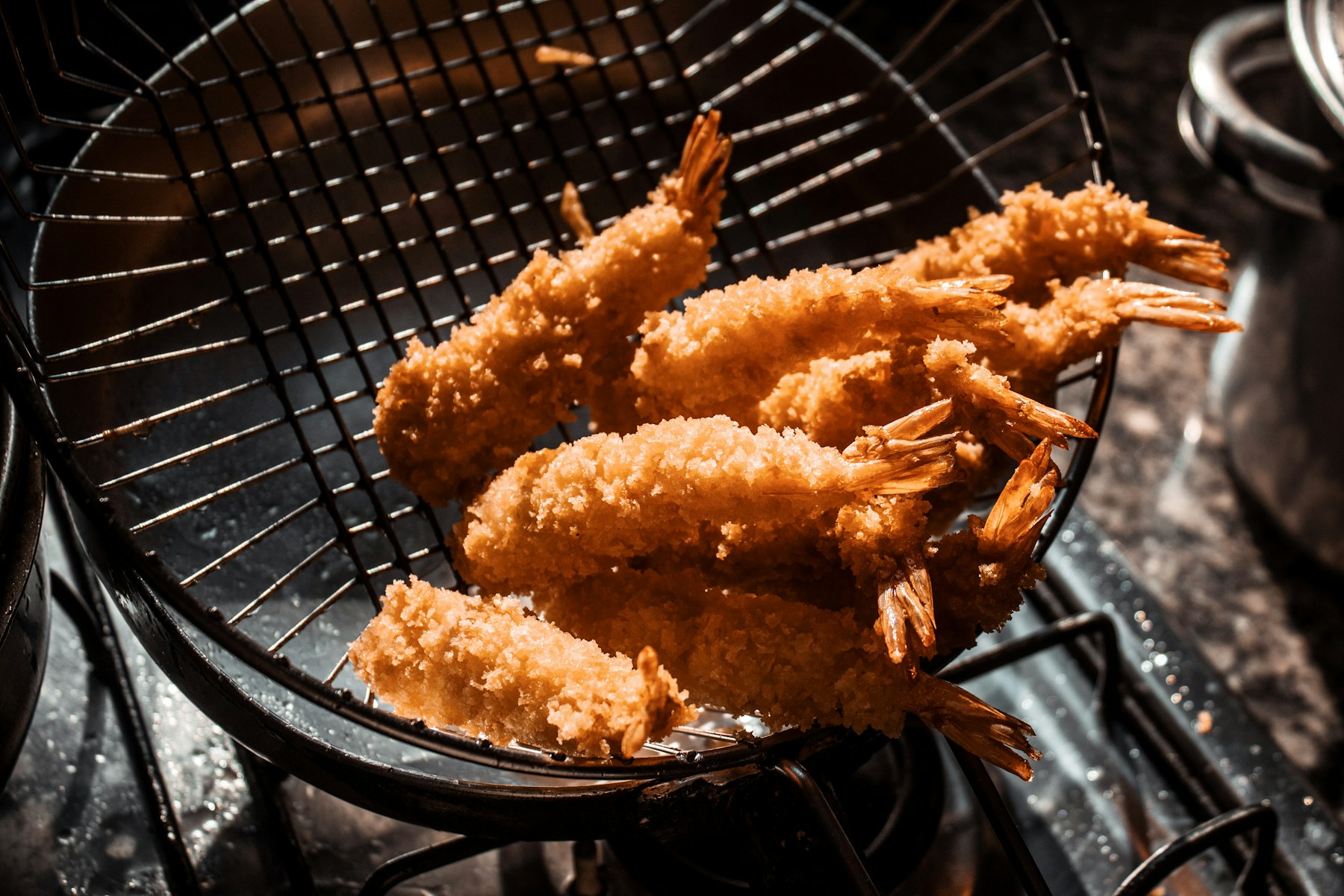 Golden fried shrimp lifted from the fryer basket
