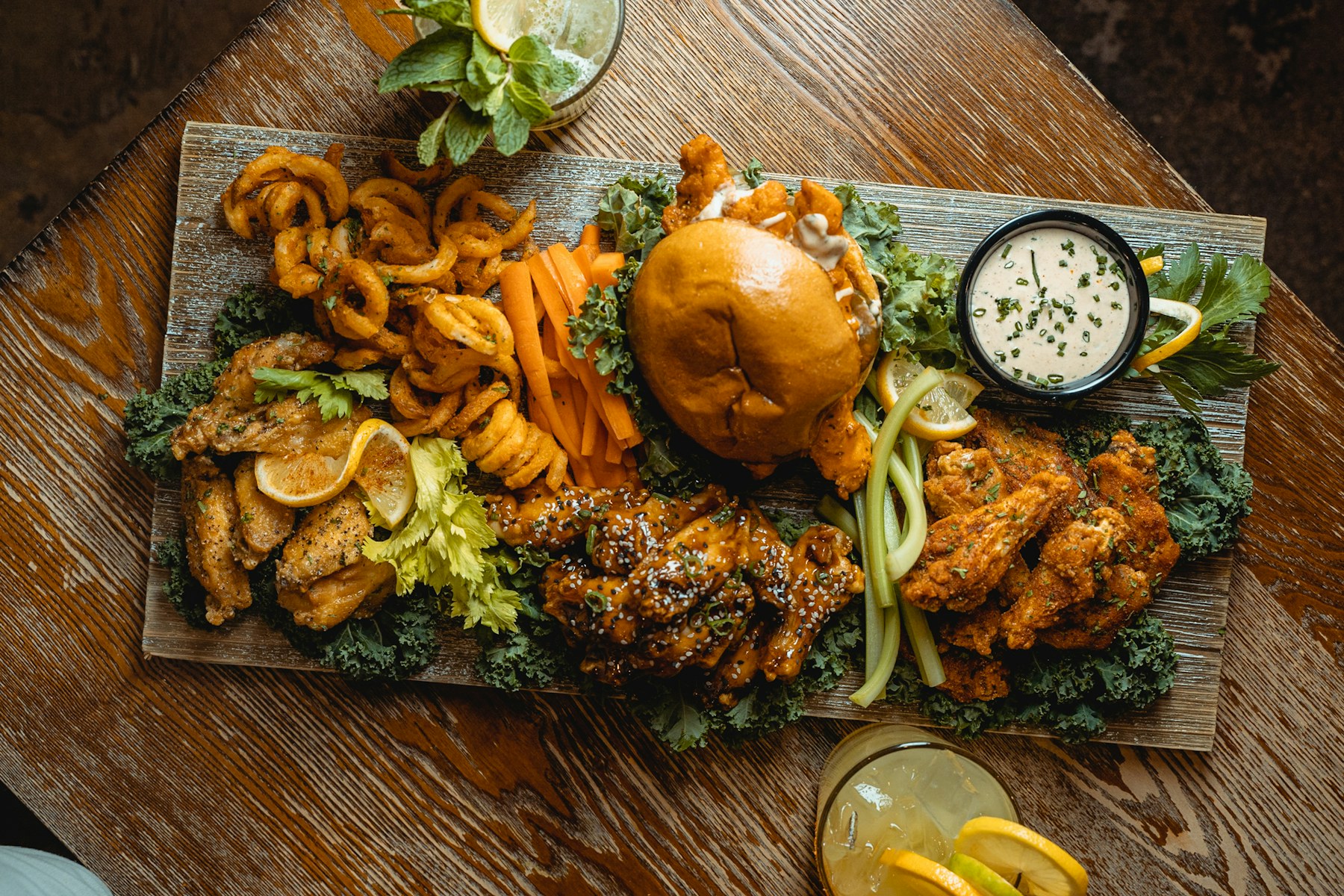 Sharing platter of wings, curly fries and a sandwich with dipping sauce