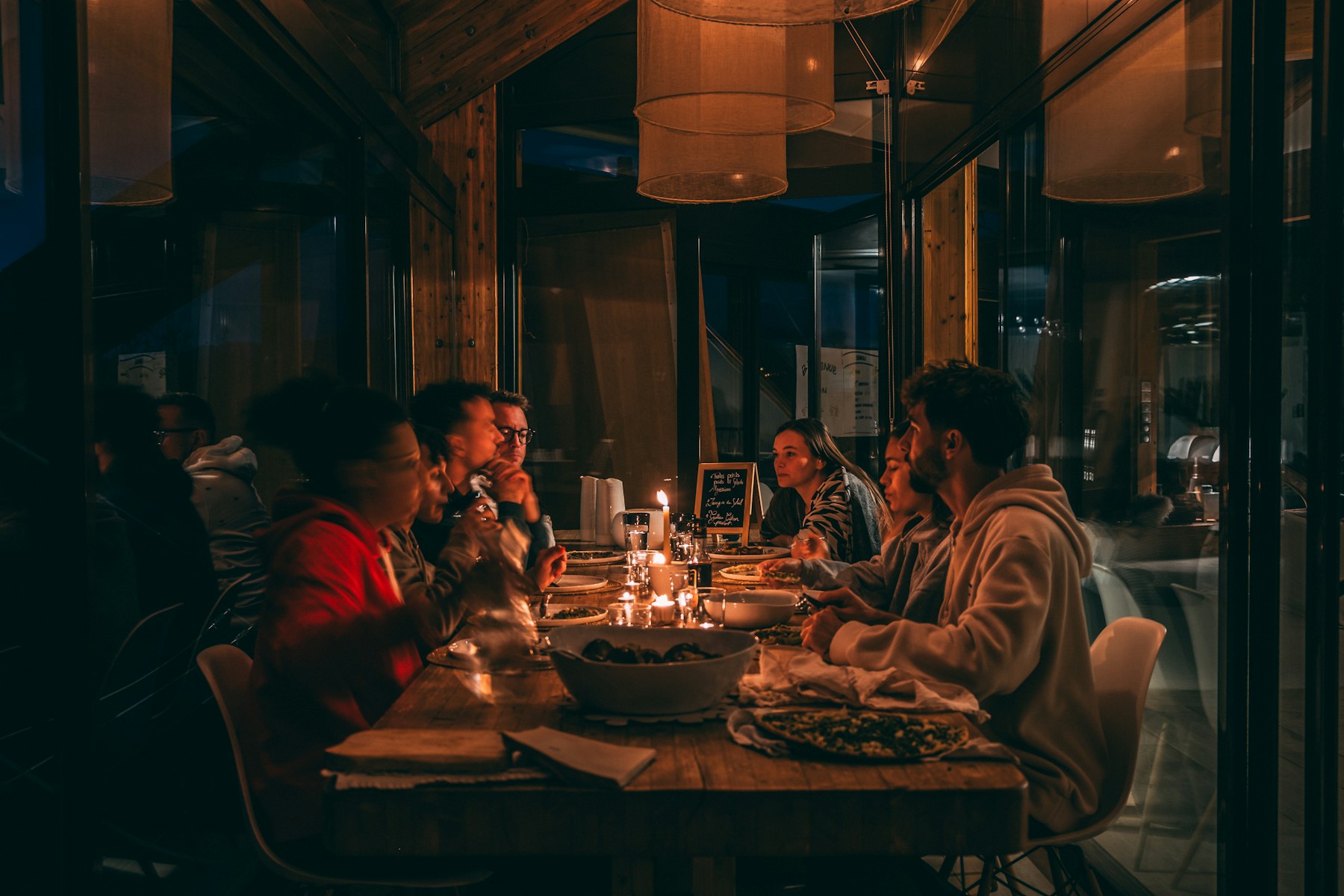 Friends sharing a meal together at a warm candlelit table